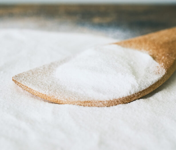 pile of white powder on table. wooden spoon in the powder.